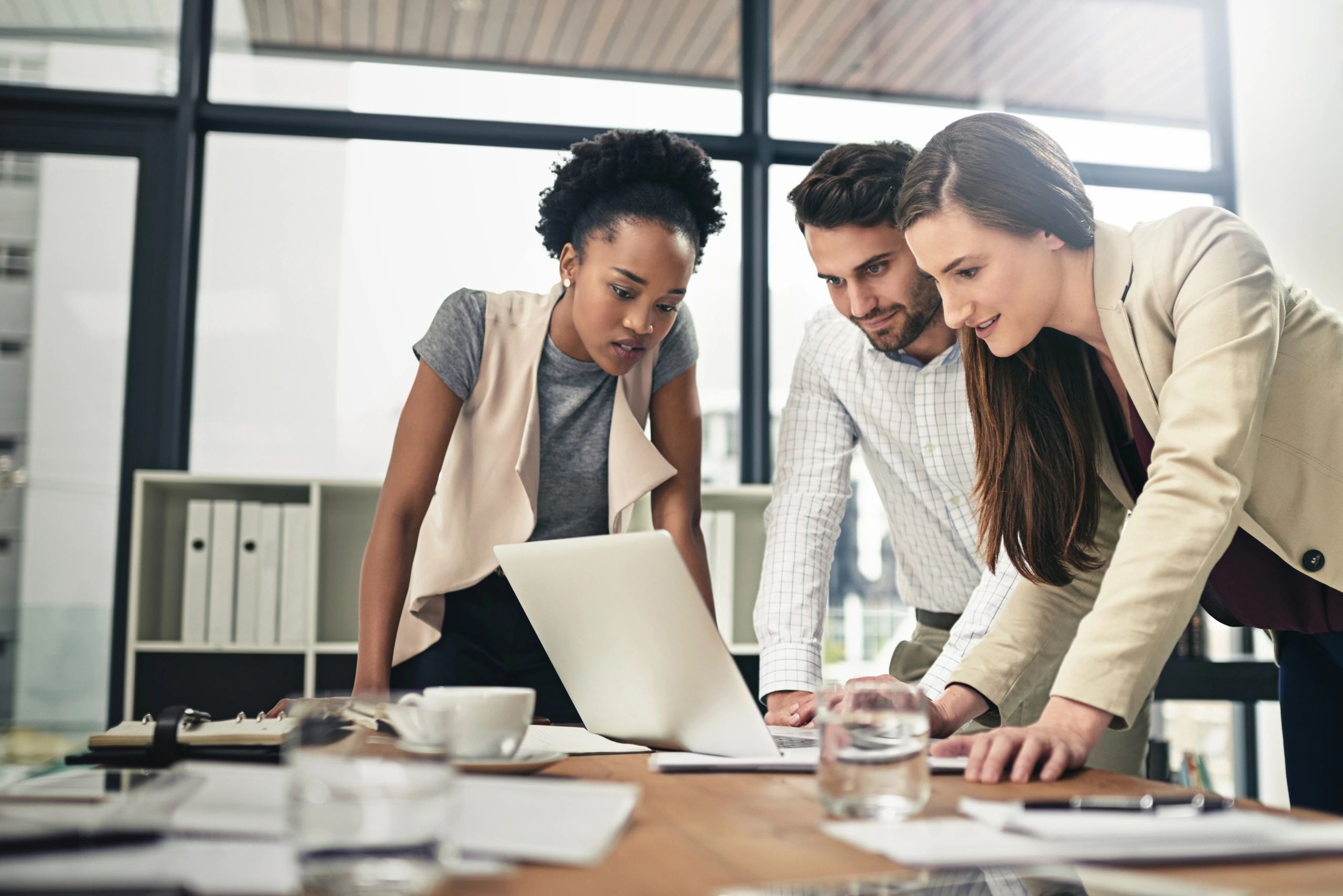 Team of businesspeople using a laptop together at work